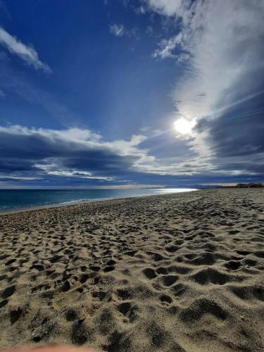a beach with footprints in the sand and the ocean at Superbe appartement cosy, proche port et plage in Leucate