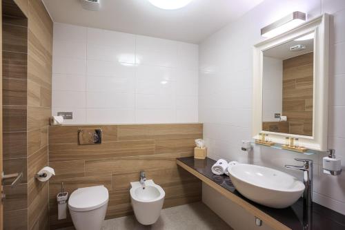 a bathroom with a sink and a toilet and a mirror at Hotel a restaurace U Vychopňů in Vsetín