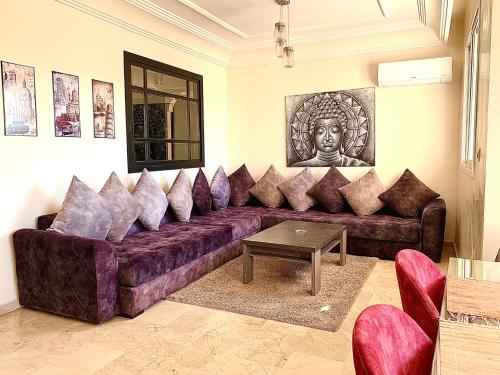 una sala de estar con un gran sofá púrpura con almohadas en Sab 12 - Amazing View of the Mosque Hassan. Luxury apartment. 2 Bedrooms., en Casablanca