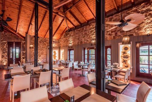 a restaurant with wooden ceilings and tables and chairs at Pinares del Cerro Resort & Suites in Villa Carlos Paz
