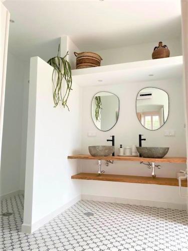 a bathroom with two sinks and two mirrors at Assumar Country House in Assumar