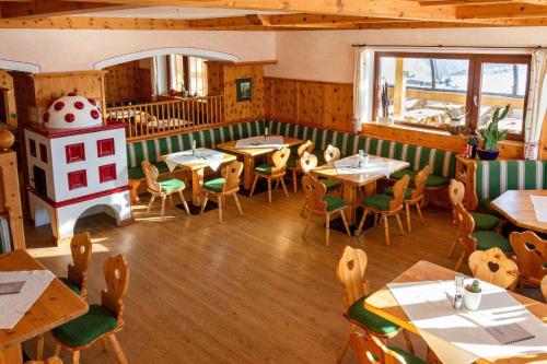 a restaurant with tables and chairs and a fireplace at Wallackhaus RegioJet Hotels in Heiligenblut