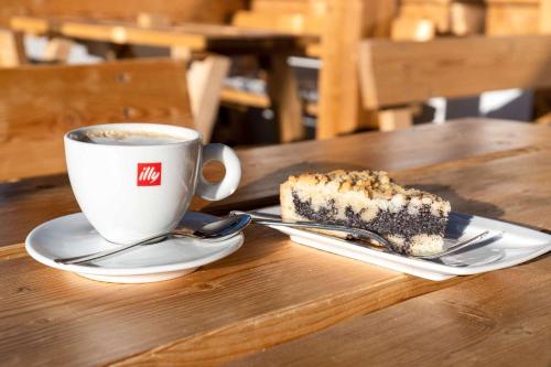 a piece of cake and a cup of coffee on a table at Wallackhaus RegioJet Hotels in Heiligenblut