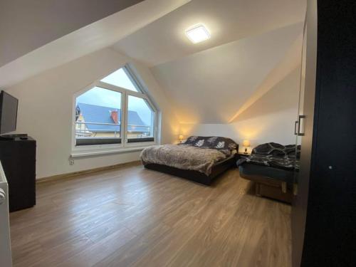 a bedroom with a bed and a large window at Apartamenty na Źródlanej in Stężyca