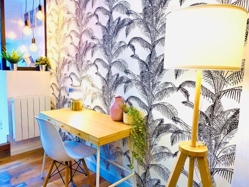 d'un bureau et d'une lampe dans une chambre avec papier peint. dans l'établissement SPLENDIDE T2 NEUF COOCOONIG AVEC PETIT PATiO, à Sète