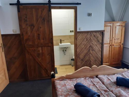 a bedroom with a sliding barn door and a bed at Na wierchu in Ząb
