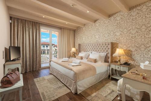 um quarto com uma cama grande e uma janela grande em Kyniska Palace Conference & Spa em Mystras