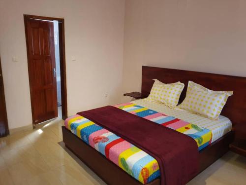 1 dormitorio con 1 cama grande con una manta colorida en Appartement chic au quartier Omnisport en Yaundé