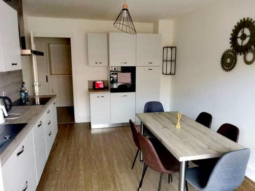 een keuken met een houten tafel en stoelen in een kamer bij Grand appartement plein centre proche bus et gare in Valence