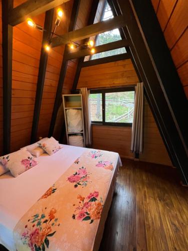a bedroom with two beds in a room with a window at URUBICI - Cabana da Montanha in Mundo Novo