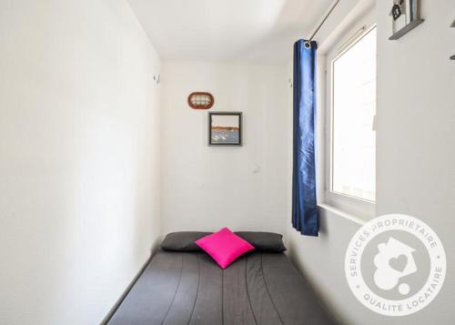 - un petit lit dans une chambre avec un oreiller rose dans l'établissement Studio Cabine Village Cap Estérel AGAY 3/4 personnes, à Drammont