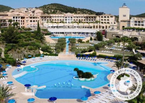 une grande piscine avec une fontaine en face du complexe dans l'établissement Studio Cabine Village Cap Estérel AGAY 3/4 personnes, à Drammont
