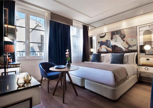 une chambre d'hôtel avec un grand lit et une table dans l'établissement Maison Colbert Member of Meliá Collection Notre-Dame, à Paris