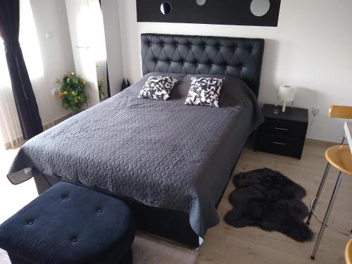 a bedroom with a large bed with a black headboard at Apartman_Park in Smederevska Palanka