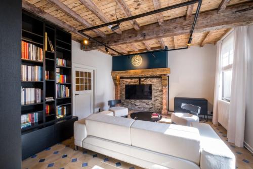 a living room with a large white couch and a fireplace at B&B Sterckxhof in Meise