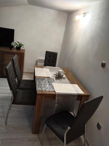 a dining room with a wooden table and chairs at Dom Mazury Harsz in Harsz