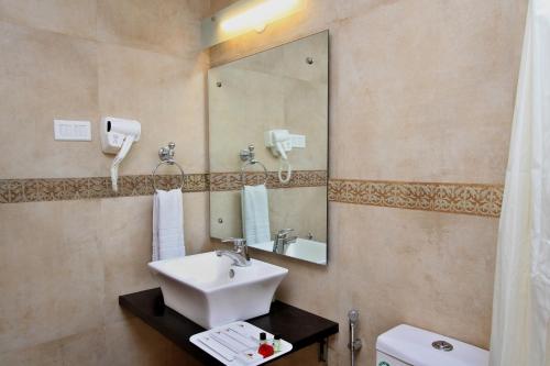 a bathroom with a sink and a mirror at Ambaari hotel in Mysore