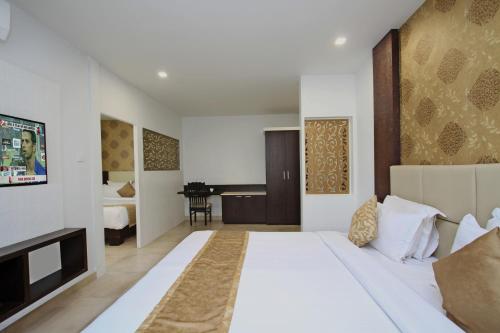 1 dormitorio con 1 cama blanca grande en una habitación en Ambaari hotel, en Mysore