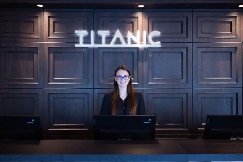 a woman sitting in front of a table with a laptop at TITANIC Comfort Kurfürstendamm in Berlin