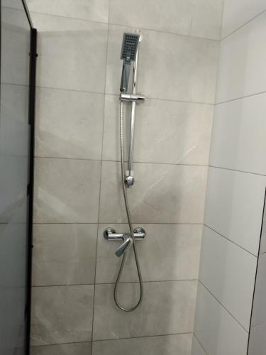 a shower with a hose in a shower stall at Dom Mazury Harsz in Harsz