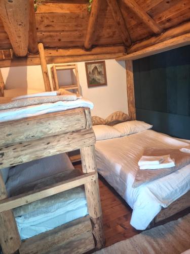 two bunk beds in a room with wooden ceilings at Mala koliba Dolina mira in Pale