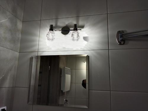 a bathroom with a mirror and a phone at Dom Mazury Harsz in Harsz