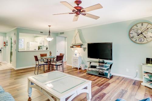 a living room with a ceiling fan and a tv at Beckenham in Hilton Head Island