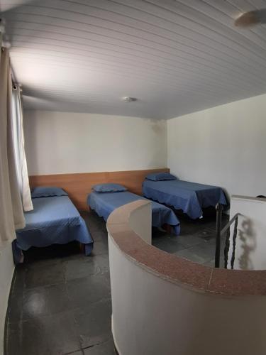 um quarto com três camas e um balcão em COBERTURA EM CABO FRIO / RJ em Cabo Frio