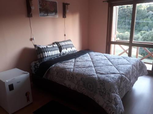 a bedroom with a bed and a window at PARADOURO BOCA DA SERRA in São Francisco de Paula