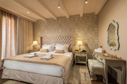 a bedroom with a large bed with two towels on it at Kyniska Palace Conference & Spa in Mystras
