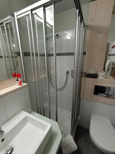a bathroom with a shower and a sink and a toilet at Gartenhotel Fettehenne in Erkrath