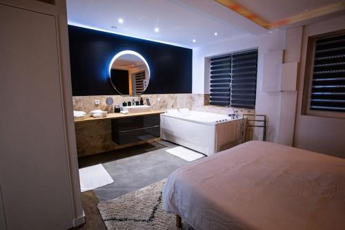 La salle de bains est pourvue d'un lit, d'un lavabo et d'un miroir. dans l'établissement BD ROOM LOVE ROOM COSY à SAINT-ETIENNE, à Saint-Étienne