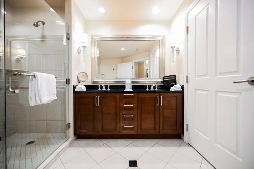 uma casa de banho com um chuveiro, um lavatório e um espelho. em StripViewSuites at Signature em Las Vegas