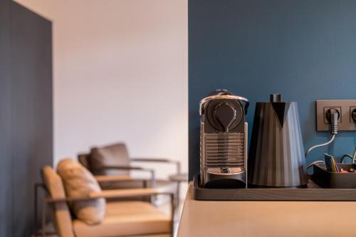 a kitchen counter with a coffee maker and a chair at B&B Sterckxhof in Meise