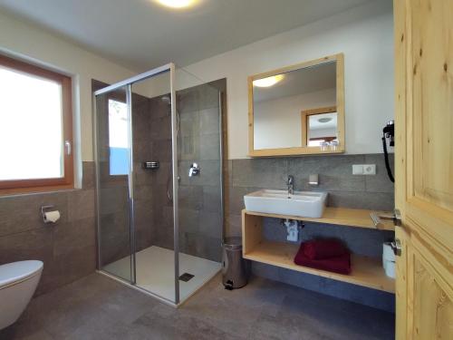 a bathroom with a shower and a sink and a toilet at Zimmererhof in Bressanone
