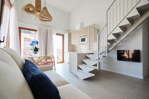 a living room with a staircase and a kitchen at Slow Home Apartments in Valencia