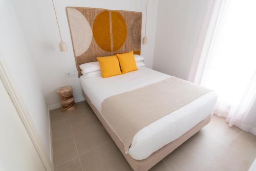 a bedroom with a bed with yellow pillows at Slow Home Apartments in Valencia