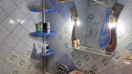 a bathroom with blue shelves on the wall at Аренда квартиры или комнат в квартире in Zhmerynka