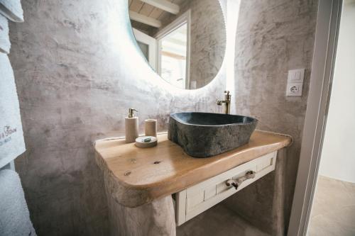 La salle de bains est pourvue d'un lavabo en pierre et d'un miroir. dans l'établissement Christine's House, à Skopelos