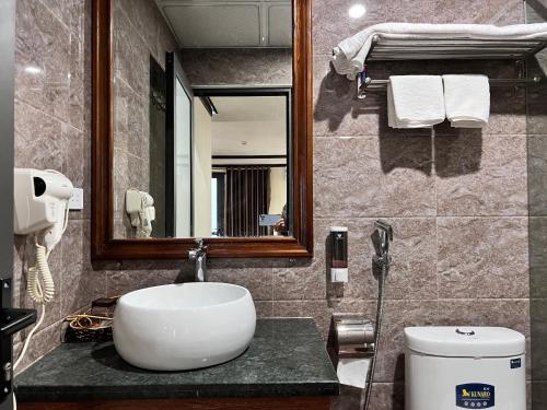 薩帕的住宿－自由沙巴酒店，一间带水槽、镜子和卫生间的浴室