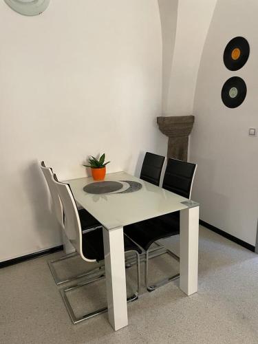 Biały stół z krzesłami i doniczką w obiekcie Apartman I Ubytovani v centru Jihlavy w Igławie