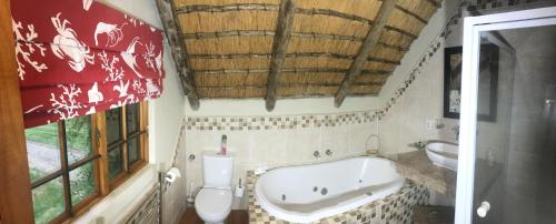 a bathroom with a tub and a toilet and a sink at Baldinnie Cottages in Nottingham Road