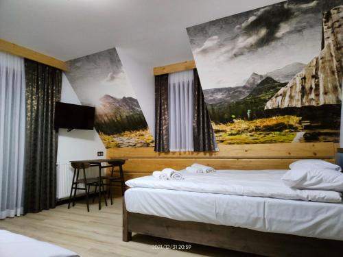 Groń的住宿－Willa Bafijówka，一间卧室设有两张床,墙上挂着一幅画