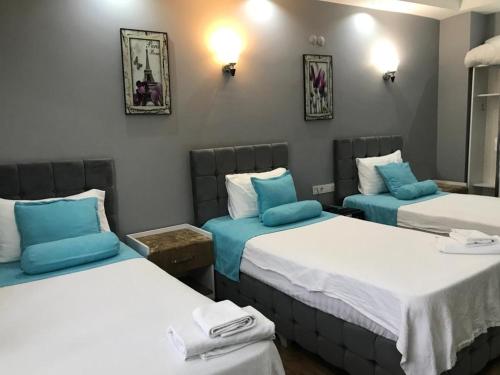 a room with two beds with blue pillows at Grand Atakum Boutıque Hotel in Mahmutlu