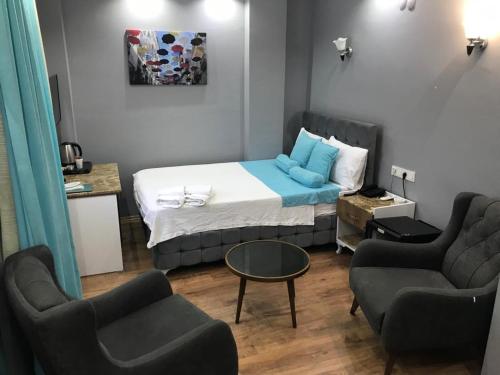 a small room with a bed and two chairs at Grand Atakum Boutıque Hotel in Mahmutlu