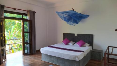 a bedroom with a large bed with pink pillows at Om yoga Shala Beruwala in Beruwala