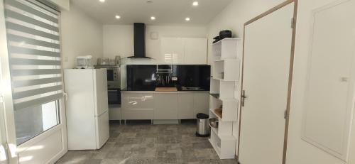 une cuisine avec des armoires blanches et un comptoir dans l'établissement Joli appartement rénové avec terrasse, à Brides-les-Bains