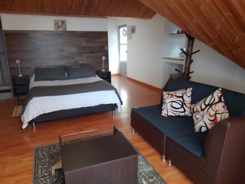 1 dormitorio con 1 cama y 1 sofá en Lago de Tota Las Heliconias en Aquitania