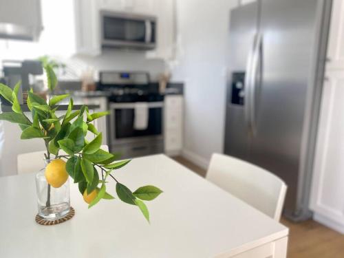 a kitchen with a table with a vase with oranges on it at Steps To The Beach, Main Street and Pacific City - OCEAN VIEWS in Huntington Beach