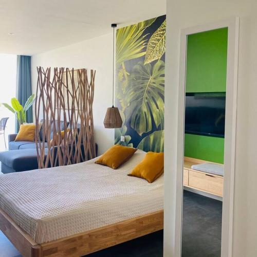una camera da letto con letto e cuscini gialli di Studio tropical, beautifully renovated, sea view ad Anse Marcel